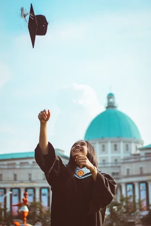 Graduate throwing a cap in front of a domed university building