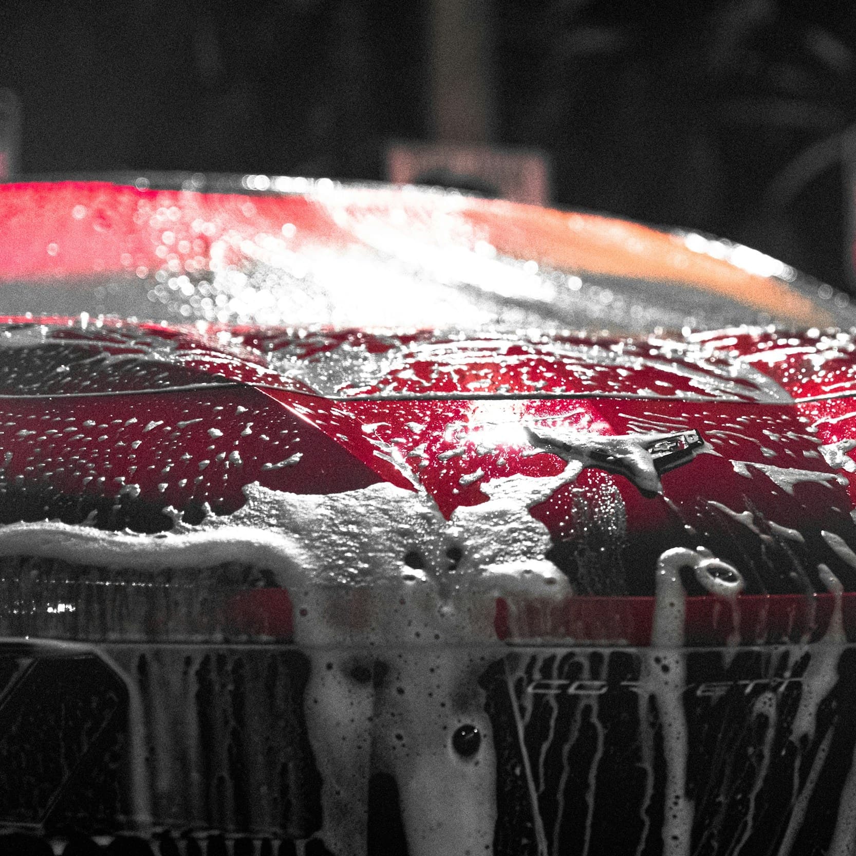 Red sports car covered in cleaning foam